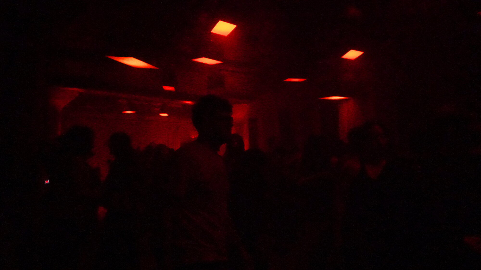 A crowd under red ceiling lights at a Uphonic AV show